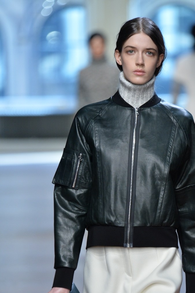 Modelo en la pasarela de Yigal Azrouel usando una chaqueta de piel tipo bomber.