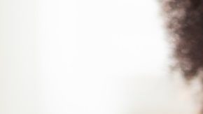 Mujer se aplica crema corporal en la parte superior del brazo.