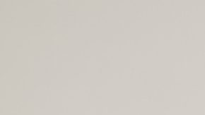 Mujer sentada posa usando una chaqueta de mezclilla oversized.