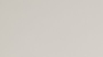 Mujer sentada posa usando una chaqueta de mezclilla oversized.