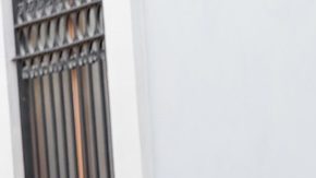 Mujer posa en Valencia con un vestido blanco primaveral con bolsillos.