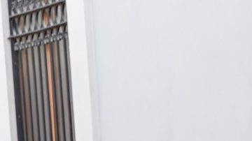 Mujer posa en Valencia con un vestido blanco primaveral con bolsillos.