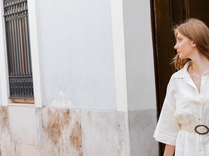 Mujer posa en Valencia con un vestido blanco primaveral con bolsillos.
