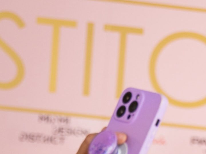 Mujer se toma una selfie frente al cartel de Stitch Lab.
