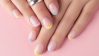 Manos de mujer con manicure francés en colors pastel.