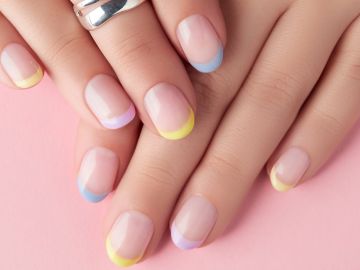 Manos de mujer con manicure francés en colors pastel.