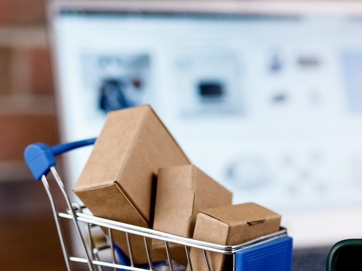 Smartphone con logo de Amazon en pantalla, carrito de compras y laptop por su Big Spring Sale 2024.