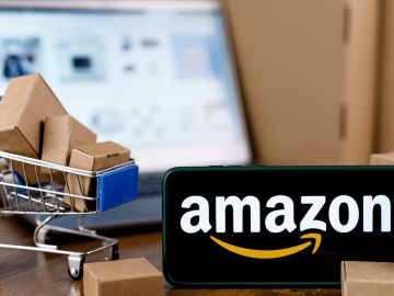 Smartphone con logo de Amazon en pantalla, carrito de compras y laptop por su Big Spring Sale 2024.