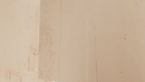 Mujer castaña posa frente a las escaleras con un conjunto primaveral de dos piezas en color camel.