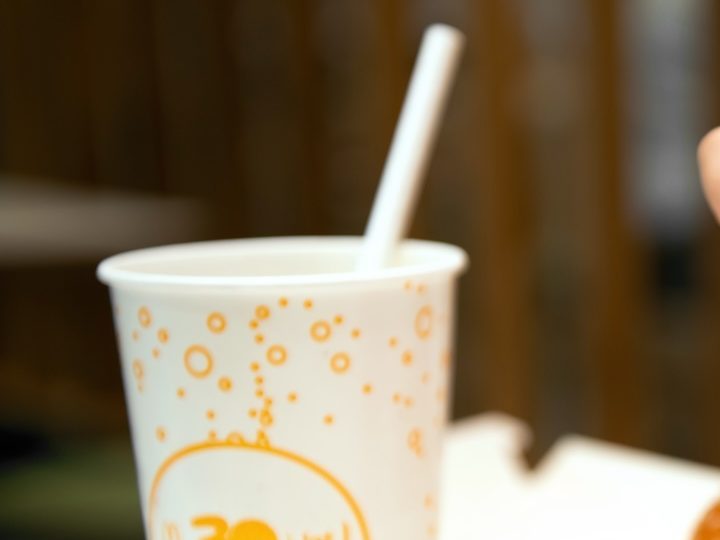 Primer plano de la mano de una mujer con manicura color amarillo tomando papas de McDonald’s.