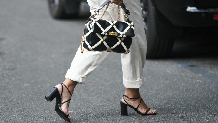 Mujer con un traje de moda y detalle en las sandalias, camina en las calles de Milán, Italia.