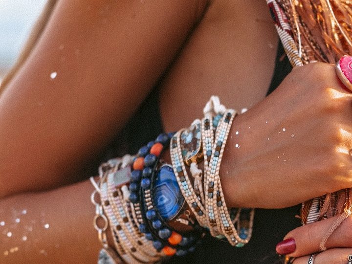 Primer plano de manos de mujer joven estilo boho con muchos accesorios y joyería