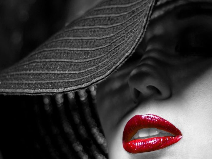 Retrato en blanco y negro de una mujer donde los labios aparecen en color rojo.
