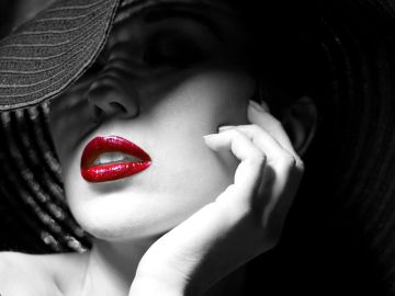 Retrato en blanco y negro de una mujer donde los labios aparecen en color rojo.
