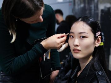 Maquillista prepara a una modelo antes del desfile de Gauchere en Paris Fashion Week FW 2024.