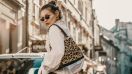 Mujer posa en la calle usando una bolsa en el hombro con estampado de leopardo.