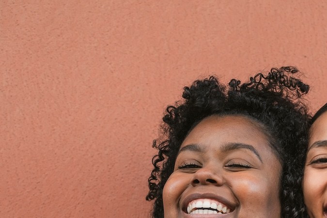 Felices amigas multirraciales divirtiéndose sonriendo juntas frente a la cámara.